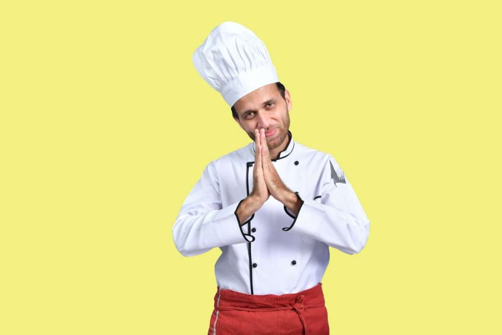 a person wearing a chef's hat and holding the chin