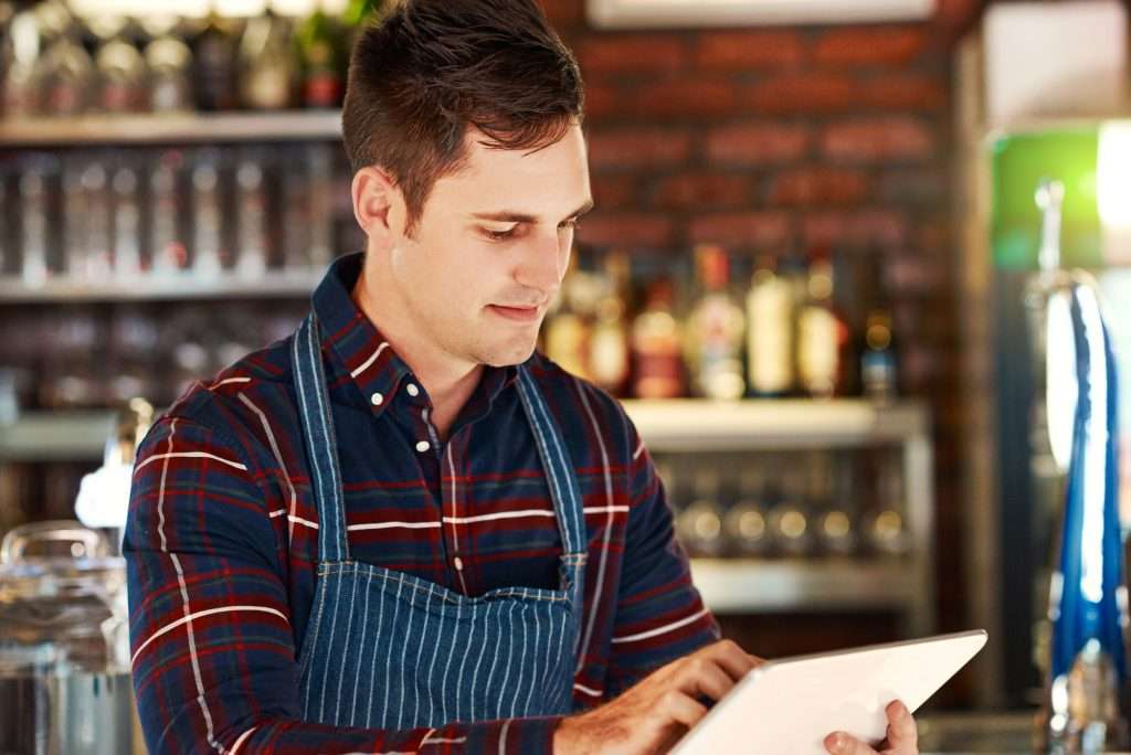 Cropped shot of a restaurant owner using a digital tablet