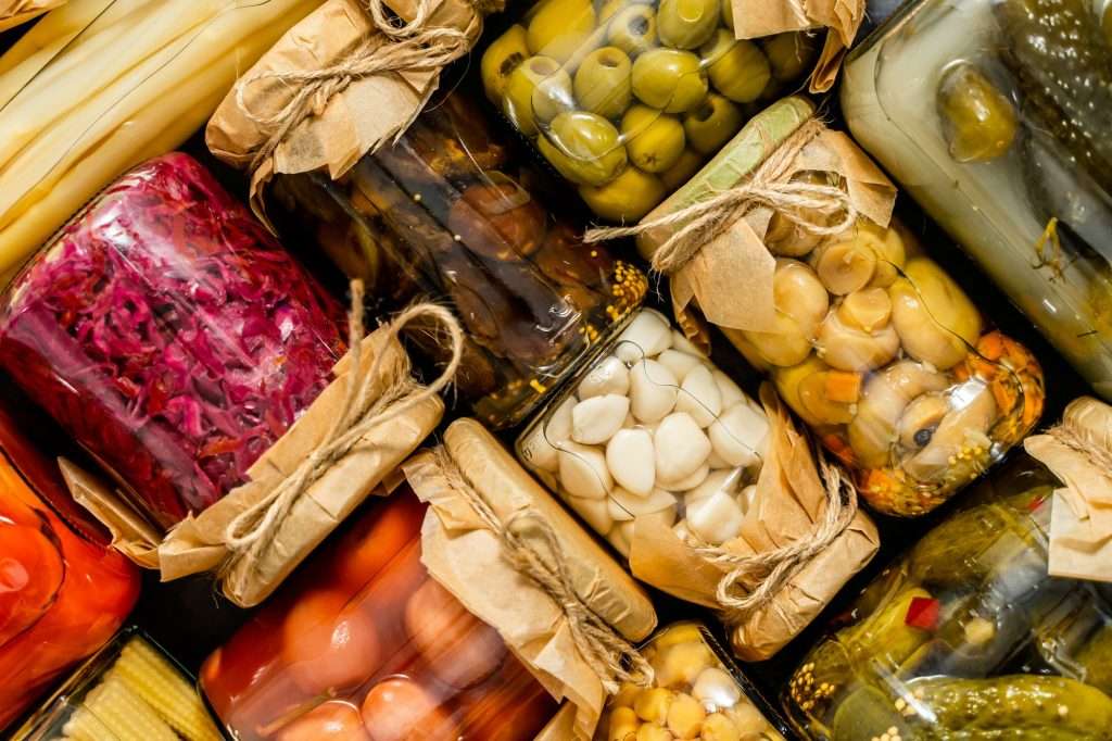 Glass jars of various preservations. Seasonal tasty vegetables