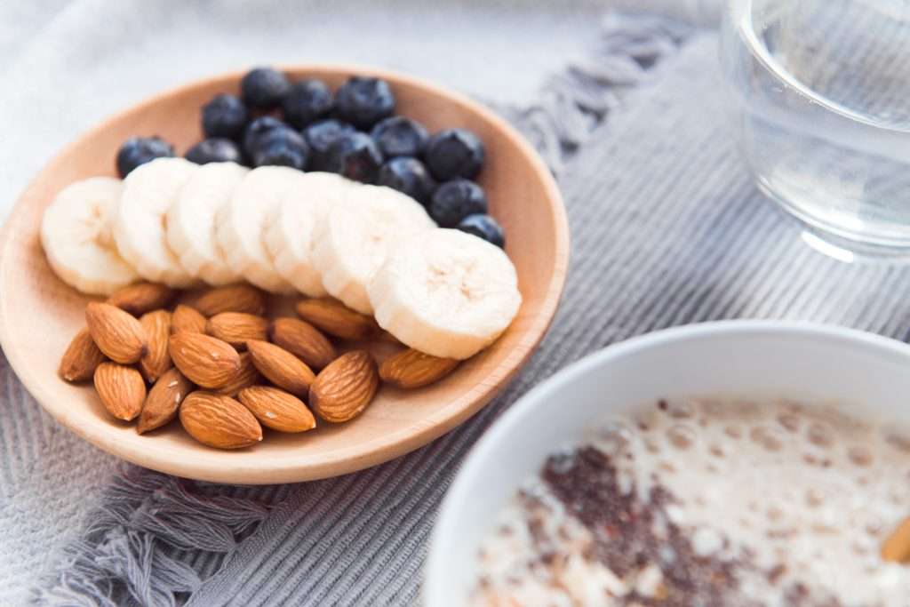 healthy snack - almond, banana and blueberry on wooden dish