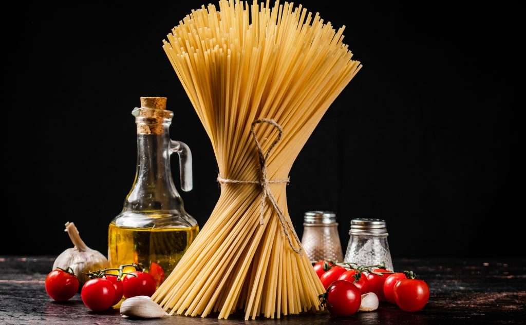 Not boiled spaghetti dry on a black background.