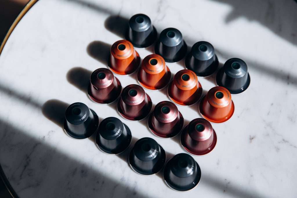 Set of colorful coffee capsules on round table