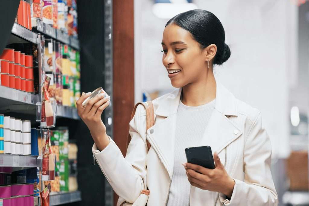 Supermarket, shopping and customer with smartphone check price, label or product information online