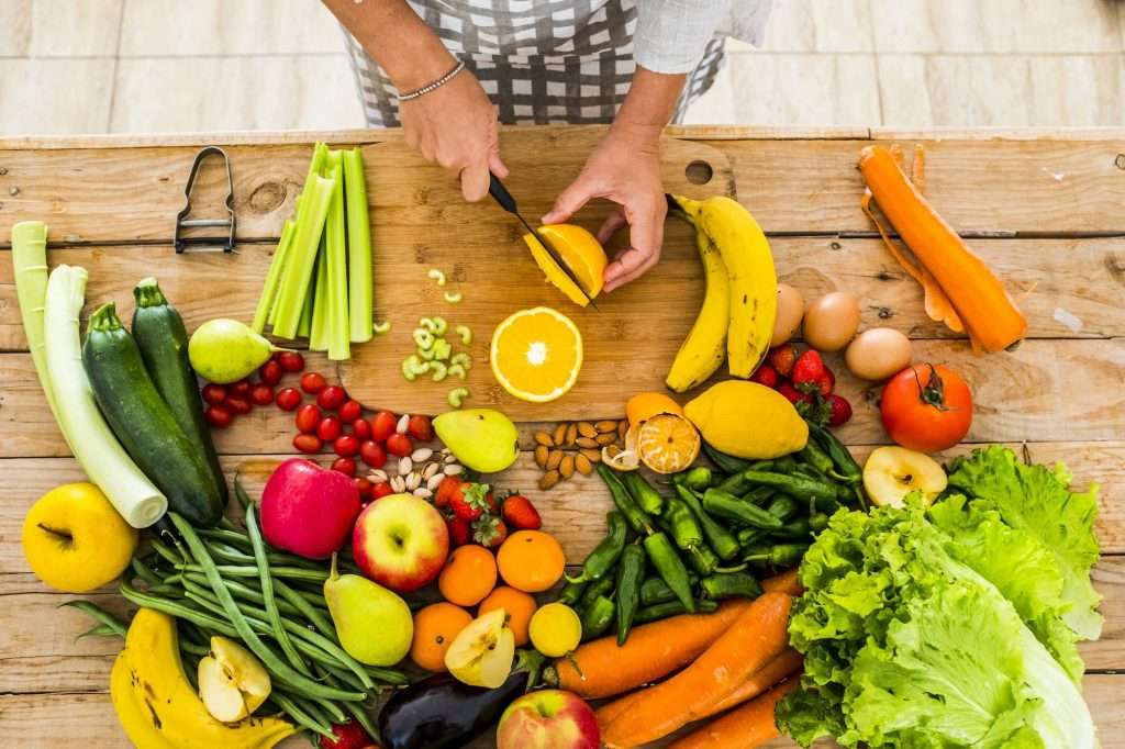 Top view of woman chef cutting and preparing food
