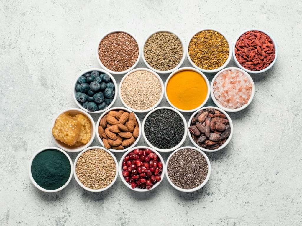 Various superfoods in bowl on gray background